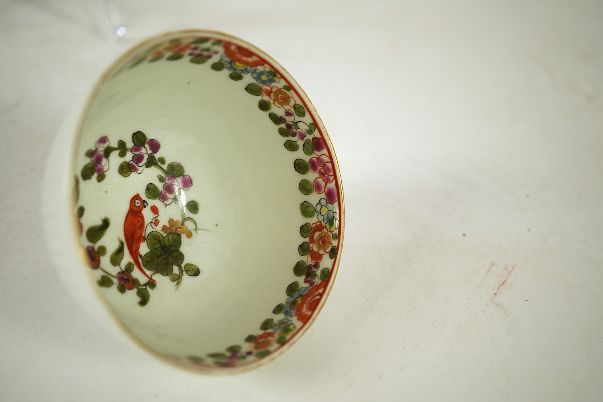 A Worcester Old Worcester Parrot pattern tea bowl and saucer, c.1765-68, saucer 11.5cm in diameter